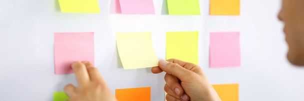 Male manager glues small notes on the wall - Photo, image