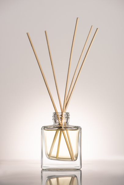fa pálcikák parfümben palackban bézs alapon - Fotó, kép