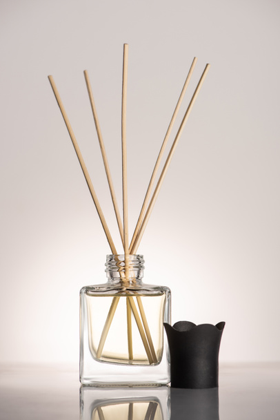 wooden sticks in perfume in bottle on beige background - Photo, Image