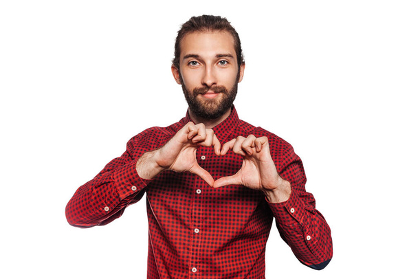 Egy fiatalember szívvel-lélekkel és mosollyal mutatja a kezét, fehér alapon. A reklám- és promóciós címkék elkülönített helye. - Fotó, kép