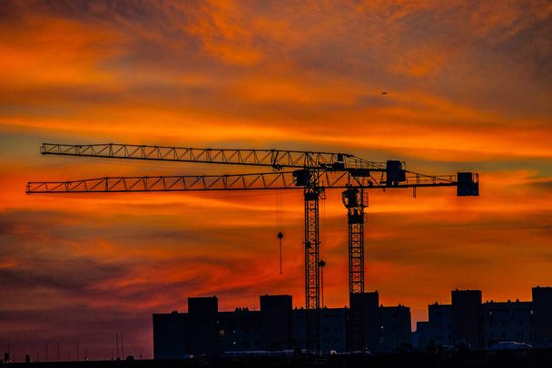 beautiful natural dramatic with clouds colorful urban sunset with construction crane - Photo, Image
