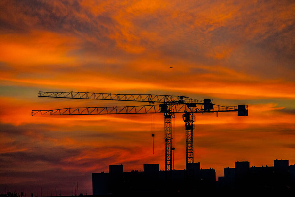 красивая природная драма с облаками красочный городской закат с строительным краном
 - Фото, изображение