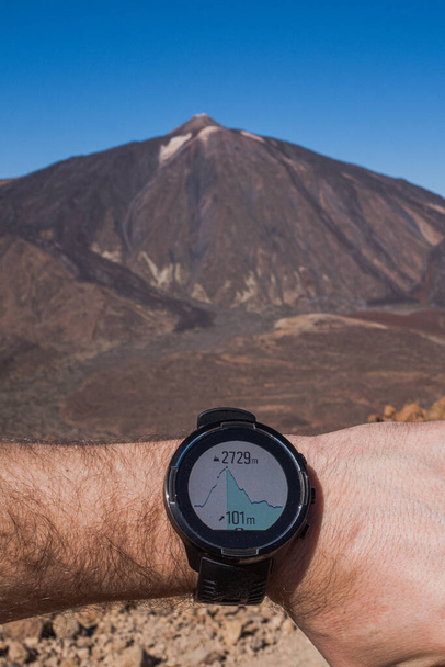 Runner vérifie les progrès de la montre intelligente. Volcan sur fond - Photo, image