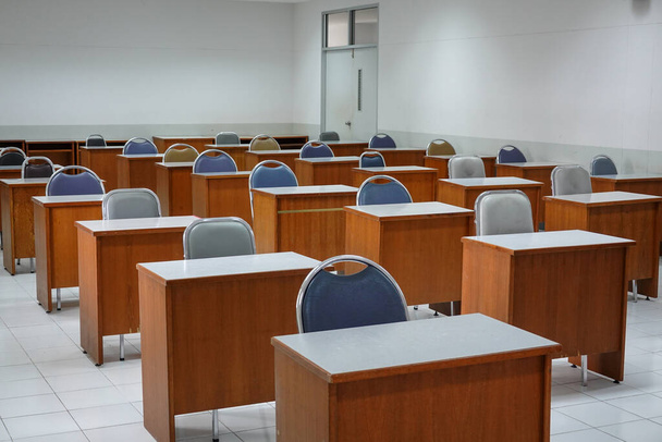 Empty classroom with vintage tone wooden chairs. Classroom arrangement in social distancing concept to prevent COVID-19 pandemic. Back to school concept. - Photo, Image