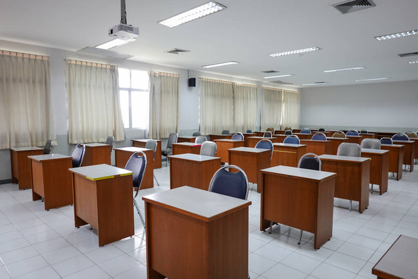 Empty classroom with vintage tone wooden chairs. Classroom arrangement in social distancing concept to prevent COVID-19 pandemic. Back to school concept. - Photo, Image