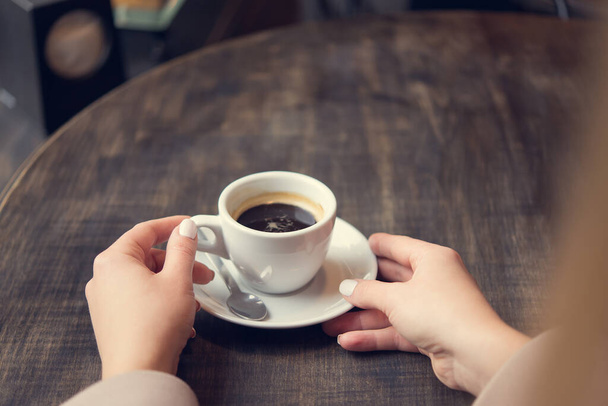 mujer con taza de café blanco en una mesa. estilo de vida de mujer de negocios. desayuno en el restaurante
 - Foto, Imagen