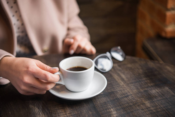 mulher com xícara de café branco em uma mesa. estilo de vida de senhora de negócios. pequeno-almoço no restaurante
 - Foto, Imagem