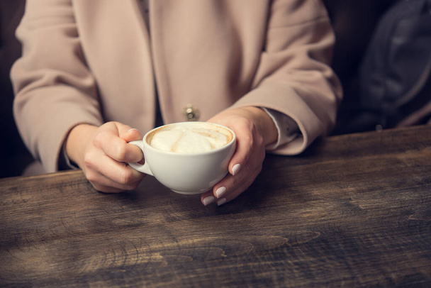 テーブルの上に白いコーヒーカップの女性。ビジネス・レディのライフスタイル。レストランでの朝食 - 写真・画像