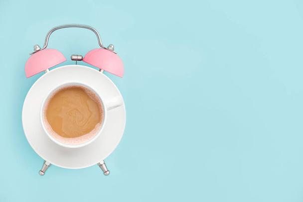 Рожевий будильник і чашка кави на синьому фоні. Концепція часу сніданку. Мінімальний стиль
 - Фото, зображення