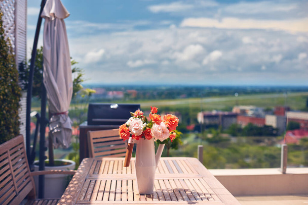 summer flower bouquet in vase on rooftop patio - Φωτογραφία, εικόνα