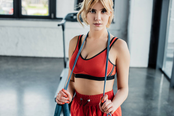 attractive sportswoman touching skipping rope and looking at camera - Foto, Imagem