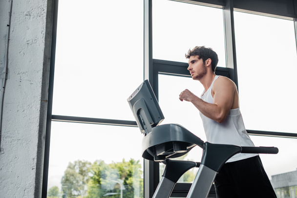 handsome man in sportswear running on treadmill  - Фото, зображення