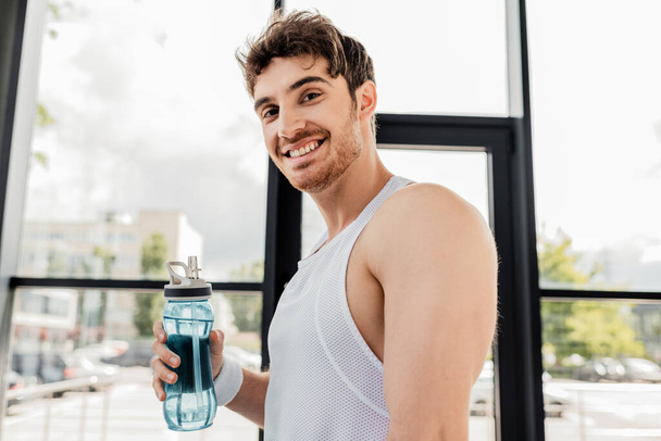 happy sportsman holding sports bottle with water - 写真・画像