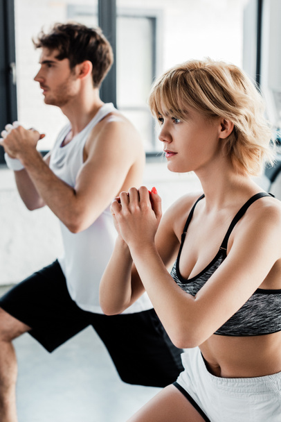 selective focus of sport couple with clenched hands working out in gym  - Foto, Imagen