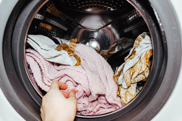 Wäscherei. Wäsche in der Waschmaschine waschen. Kleidung aus der Wäsche holen. - Foto, Bild