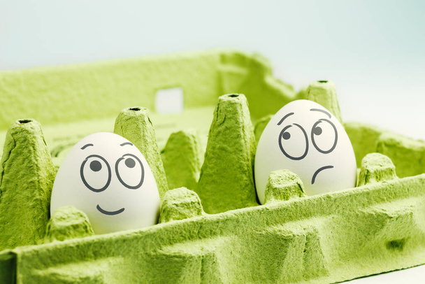 Two eggs in eggbox. Optimist and pessimist - Valokuva, kuva