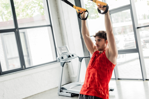 guapo y atlético deportista haciendo ejercicio con elásticos en el gimnasio
  - Foto, imagen