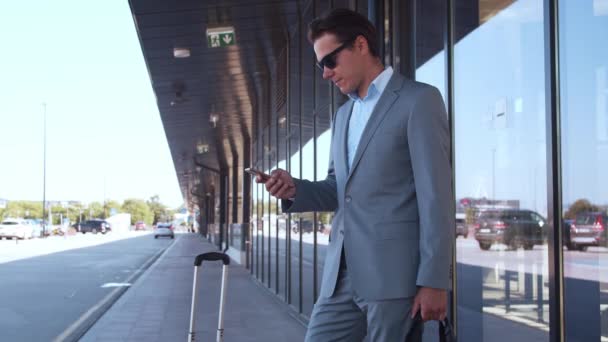 Elegant businessman in airport. Young mail entrepreneur in formalwear. Business trip and traveling concepts. - Footage, Video