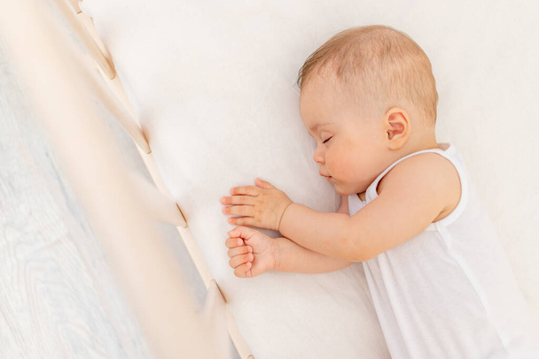Kleines Mädchen 6 Monate alt schlafend in einem weißen Bett, gesunder Babyschlaf - Foto, Bild