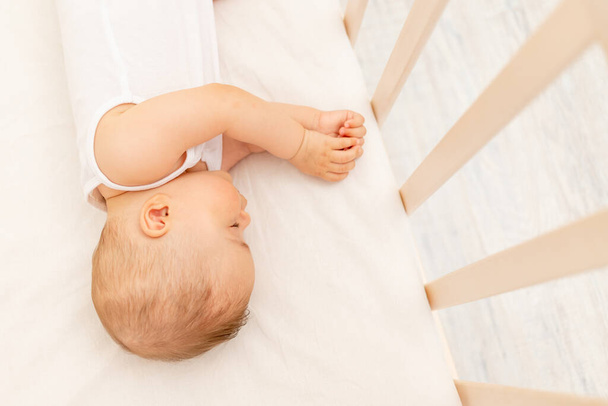 Piccola bambina di 6 mesi che dorme in un letto bianco, sonno sano del bambino - Foto, immagini