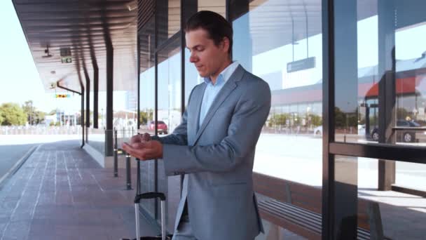 Elegant businessman wearing protective mask in airport. Young mail entrepreneur in formalwear. Pandemic, new rules of control, business trip and traveling concepts. - Materiał filmowy, wideo
