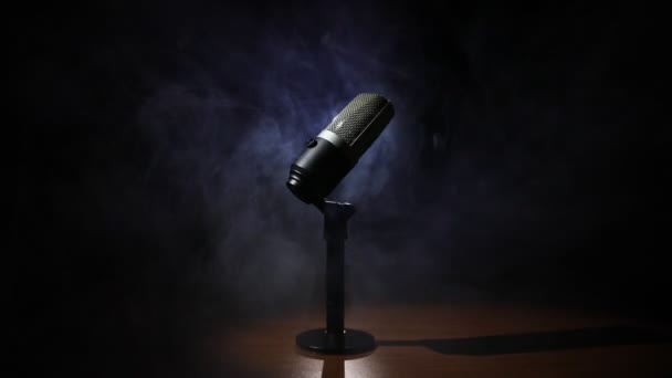 Microphone for sound, music, karaoke in audio studio or stage. Mic technology. Speech broadcast equipment. Microphone in dark room on table with backlight. Selective focus - Footage, Video