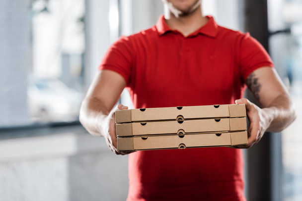 обрезанный вид курьера с коробками для пиццы
  - Фото, изображение