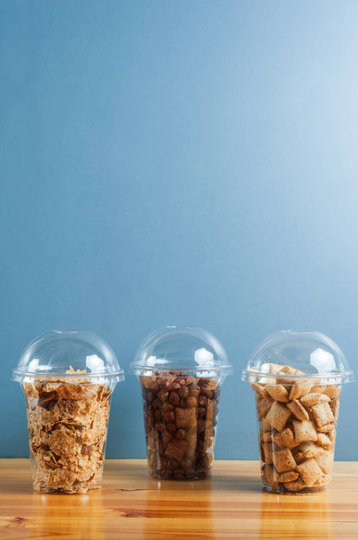 Desayuno de cereales en cajas de transformantes en café o en restauracion a fondo azul. vertical - Foto, Imagen