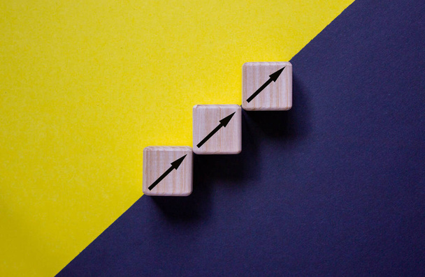 Business concept growth success process. Wood block stacking as step stair on paper yellow and black background, copy space. - Фото, изображение
