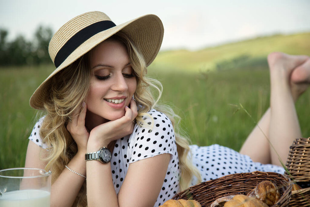 Piękna młoda kobieta na zewnątrz. Zdrowe, uśmiechnięte dziewczyny w zielonej trawie. piknik na wsi na trawniku - Zdjęcie, obraz