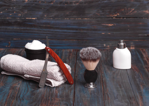 Różne maszynki do golenia, szczotka, perfumy i pianka do golenia na drewnianym tle - Zdjęcie, obraz