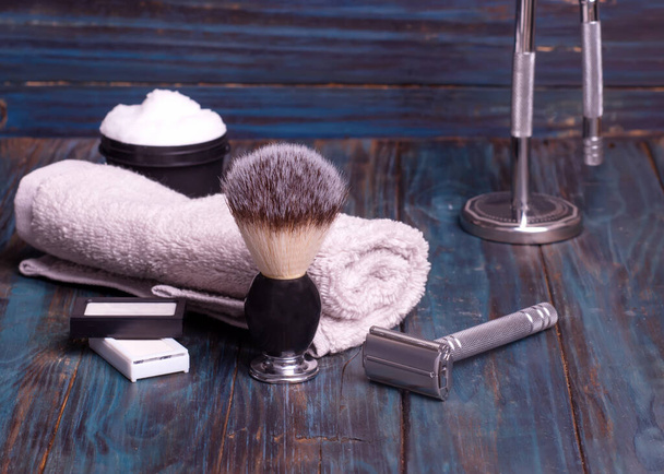 Diferentes maquinillas de afeitar, cuchillas, cepillo, perfume y toalla sobre un fondo de madera
 - Foto, imagen