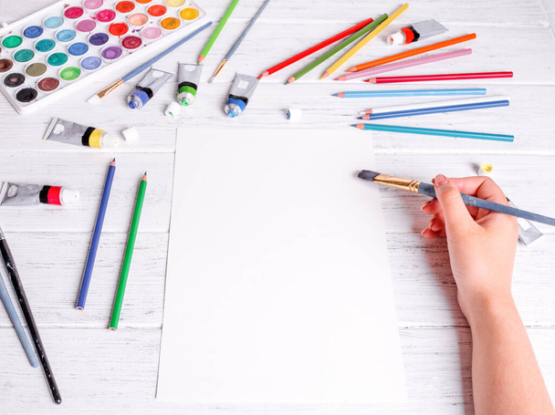 Resim ve çizim için bir model. Kalem fırçasını tutan ve beyaz kağıda çizen eller. Yukarıdan görüntüle. - Fotoğraf, Görsel