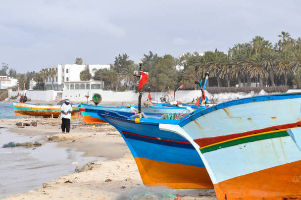 Хаммамет, Тунис - 07 февраля 2009 года: Тунисские рыбацкие лодки на пляже с их традиционными цветами
. - Фото, изображение