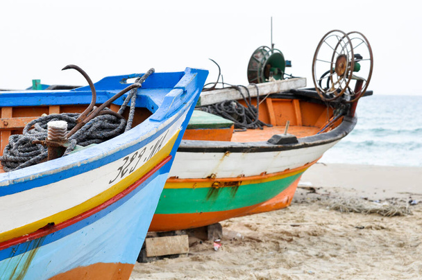 Hammamet, Tunesien - 07. Februar 2009: Tunesische Fischerboote am Strand mit ihren traditionellen Farben. - Foto, Bild