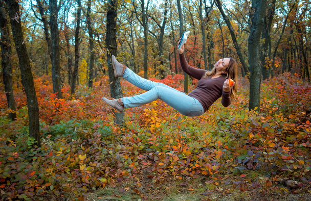 Levitation. The emotions of a young woman. Flying in the autumn forest. - Photo, Image