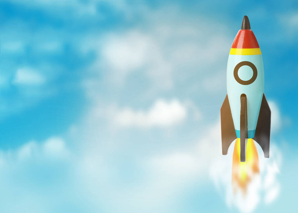 Business startup concept. Modern rocket flying in blue sky, space for text - Фото, изображение