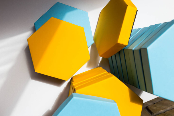 A close up beautiful blue and yellow hexagon boxes of present on the white background. Place for text. Empty centre. Top view. Flat lay. Mockup - Valokuva, kuva