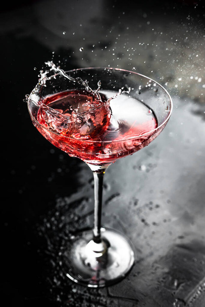 A splash in a beautiful cocktail glass with cosmopolitan - Zdjęcie, obraz