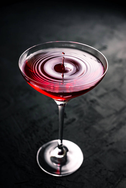 A drop falling into a beautiful cocktail glass with cosmopolitan - Foto, Imagem