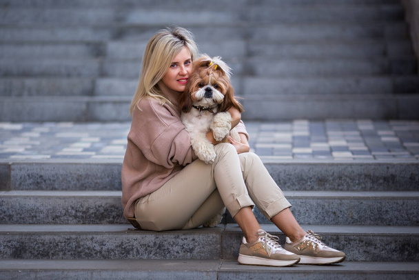Beautiful woman with a cute pet dog, Shih Tzu. Sitting in a stone staircase. Lifestyle - Foto, immagini