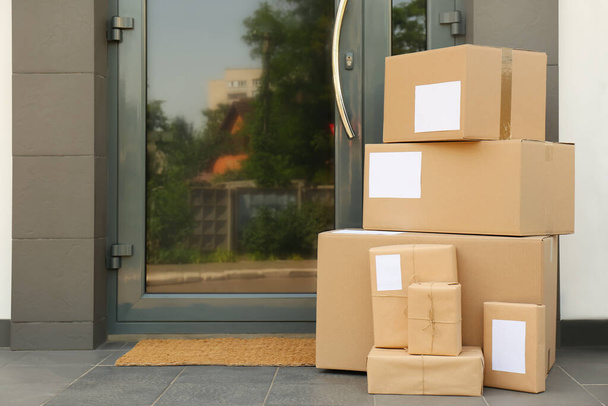 Cardboard boxes near door. Parcel delivery service - Zdjęcie, obraz