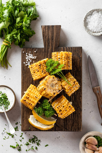 corn on cob bbq on a cutting board on a white background, view from above - Fotoğraf, Görsel