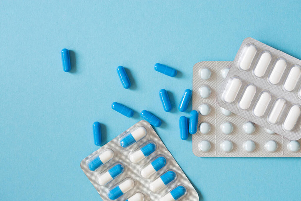 Erilaisia lääkkeitä, tabletteja, kapseleita sinisellä taustalla. Farmaseuttiset aiheet - Valokuva, kuva