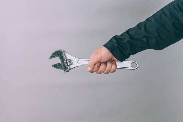 A man holds in his hands a metal wrench for work - Foto, Imagen