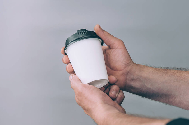 Mock-up for logos and design. A man holds in his hand a glass of coffee - Foto, imagen