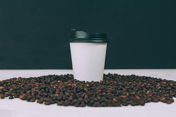 Disposable coffee glass on a background with coffee beans - Foto, immagini
