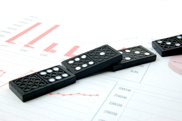 Domino arriscado sobre um gráfico de negócios financeiros
 - Foto, Imagem