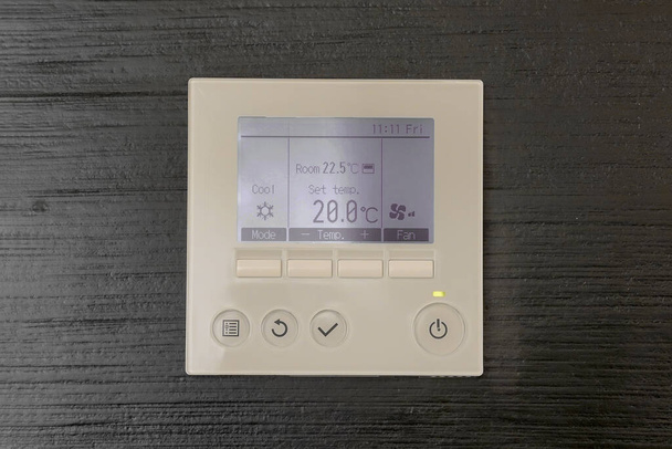 Ovládací panel klimatizace. Digitální termostat na černé dřevěné stěně. Digitální programovatelný termostat. - Fotografie, Obrázek