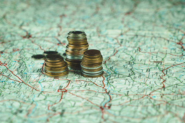 Heap of coins on a map. Tourism concept. Savings to travel. Economic budget - Foto, Bild
